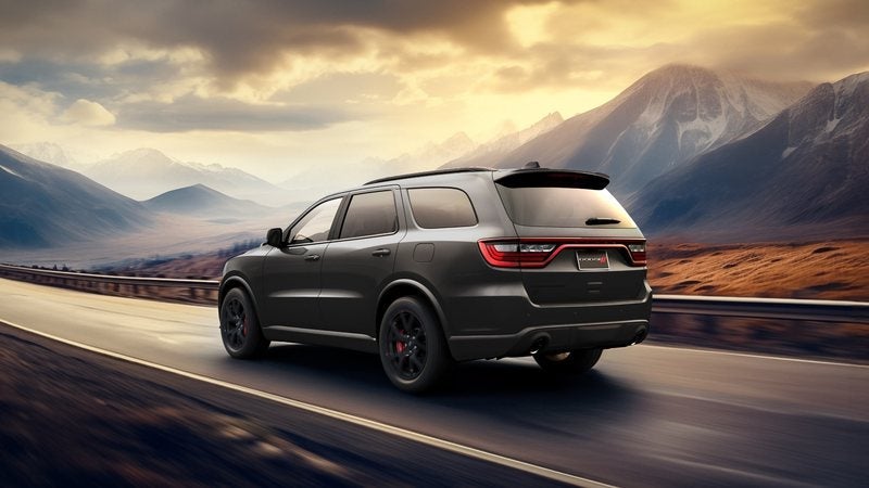 Dark gray 2027 Dodge Durango driving on a mountain highway; Dodge Durango specials at Ross Downing CDJR in Hammond, LA