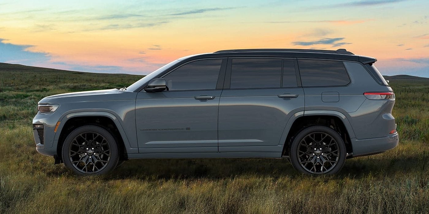 Gray 2027 Jeep Grand Cherokee L Summit 3-row SUV in side profile in a grassy field at sunset, new at Ross Downing CDJR in Hammond, LA