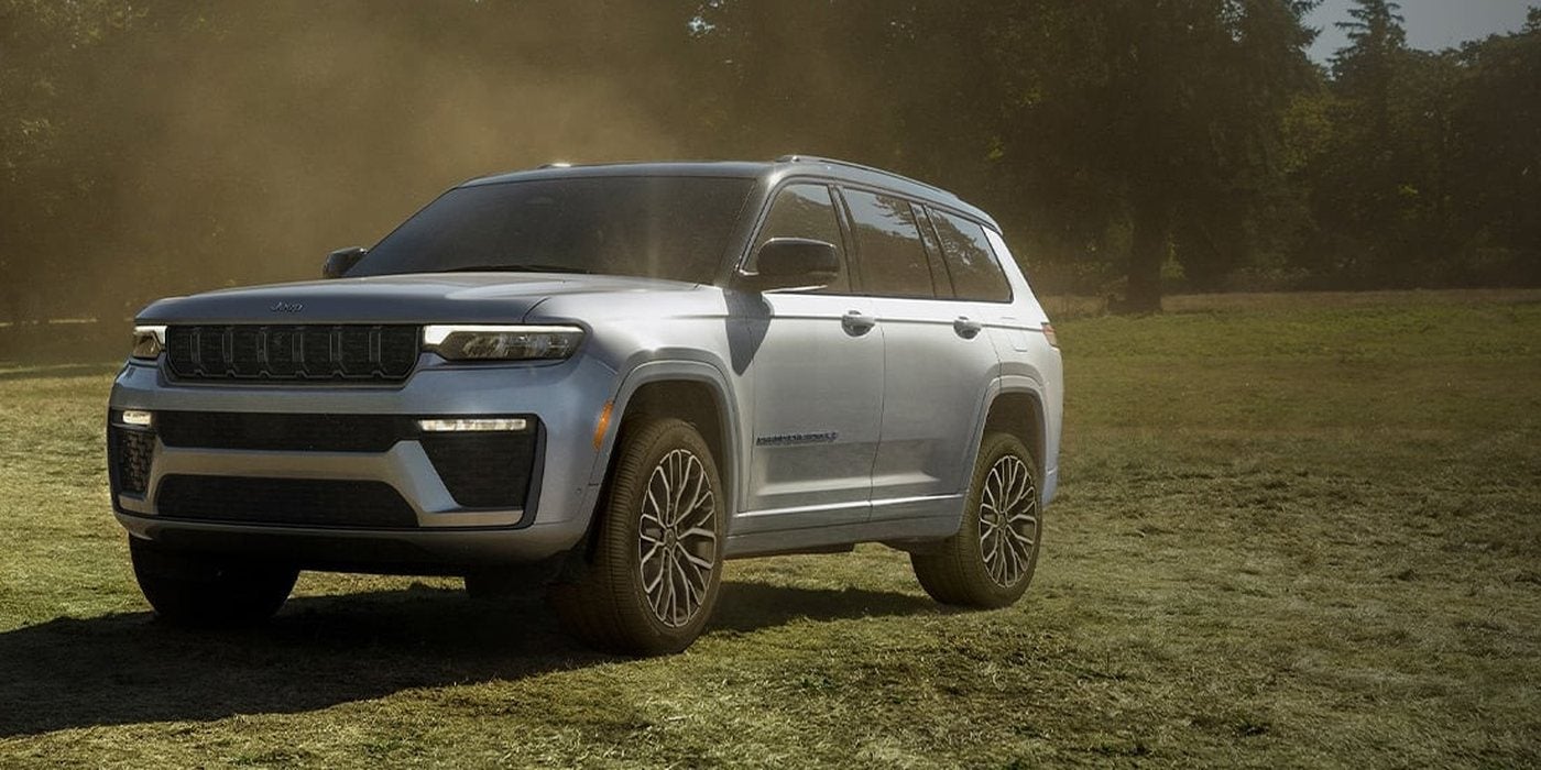 Silver 2027 Jeep Grand Cherokee L 3-row SUV parked in a sunlit meadow, for sale at Ross Downing CDJR in Hammond, LA