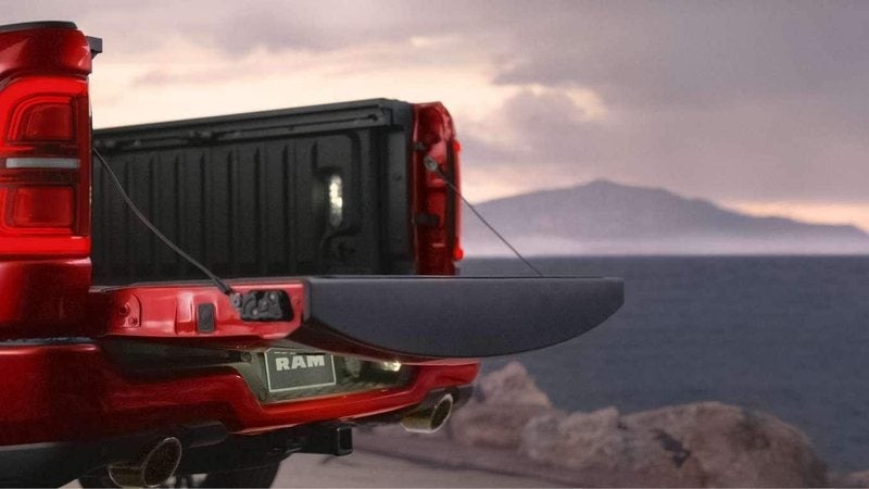 Red 2027 Ram 1500 Tungsten with its tailgate open by the sea; Ram 1500 financing at Ross Downing CDJR in Hammond, LA