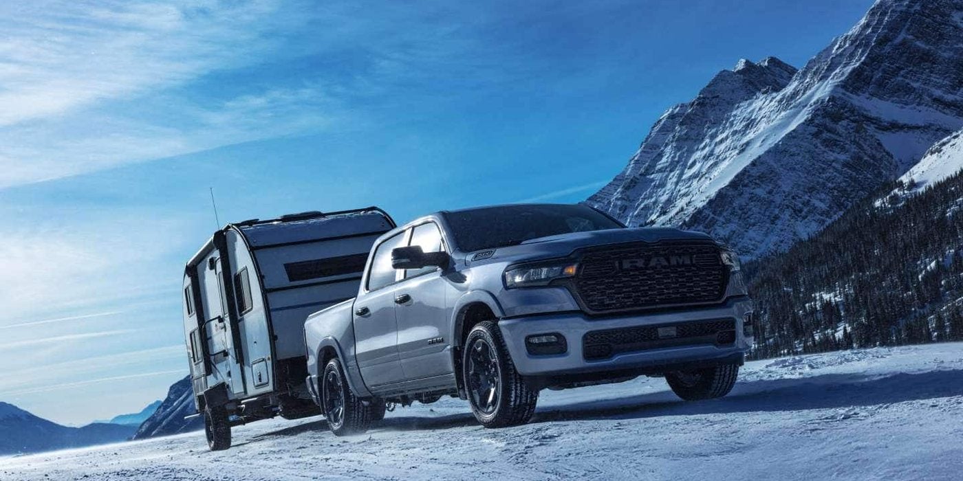 2027 Ram 1500 Big Horn Crew Cab towing a travel trailer through snowy mountains, for sale at Ross Downing CDJR in Hammond, LA
