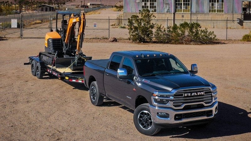 2027 Ram 3500 Laramie Crew Cab hitched to a trailer carrying a mini excavator; Ram 3500 specials at Ross Downing CDJR in Hammond, LA