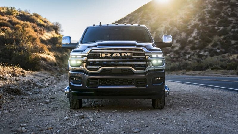 Front view of a black 2027 Ram 3500 Laramie on a mountain highway at sunset; Ram 3500 financing at Ross Downing CDJR in Hammond, LA