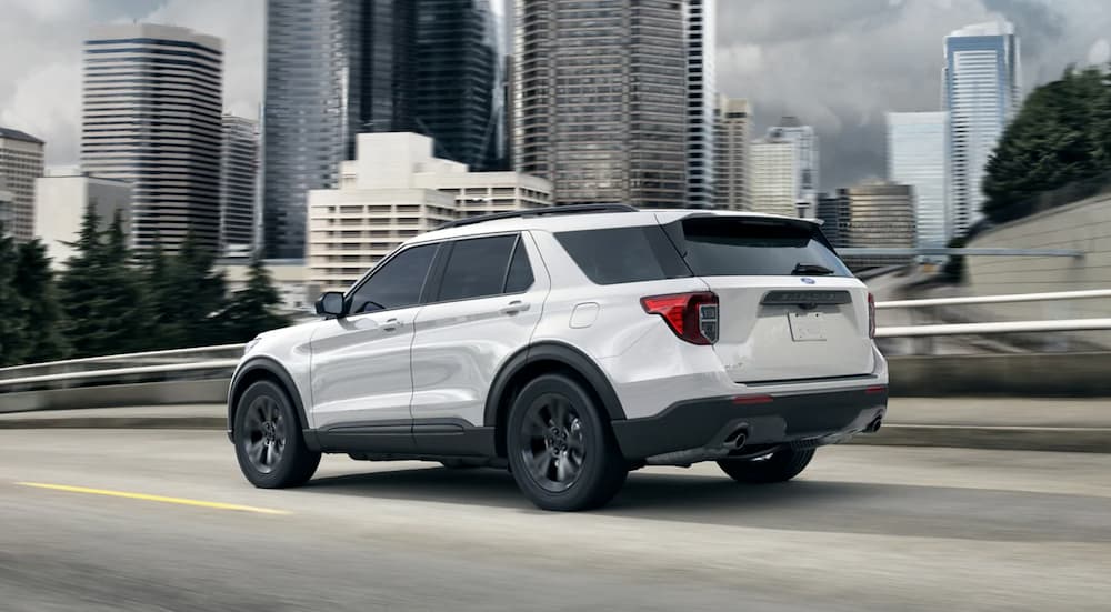A white 2021 Ford Explorer driving to view a used Ford for sale.
