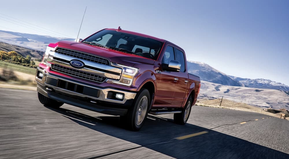 Red 2020 Ford F-150 driving down an open road.