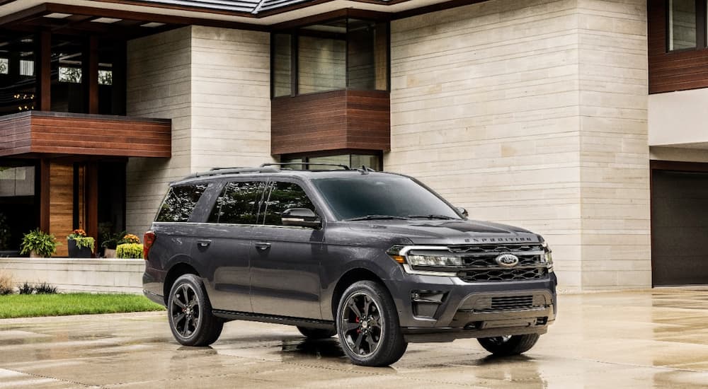A gray 2022 Ford Expedition parked near a modern house.