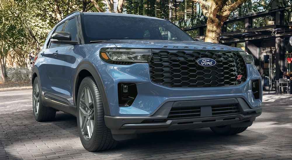 A blue 2027 Ford Explorer ST parked on cobblestone.