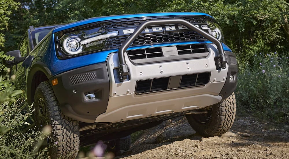 Front of a blue 2026 Ford Bronco Sport for sale driving up a hill.