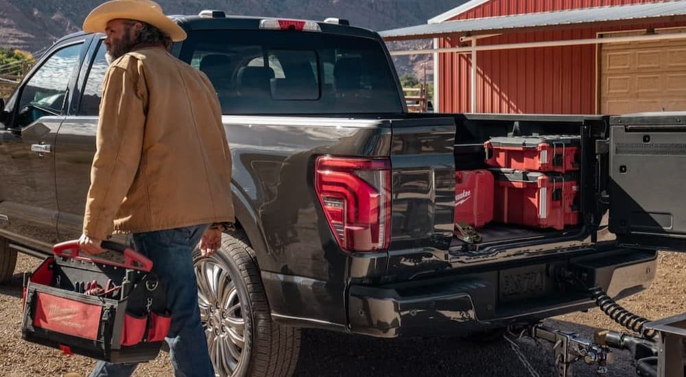A person walking near the bed of a gray 2026 Ford F-150.