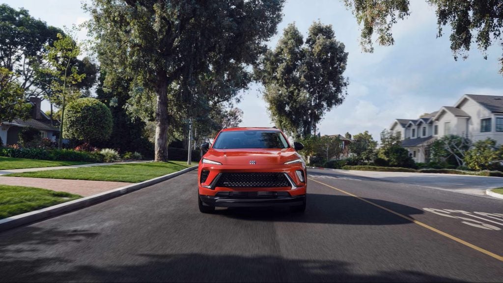 Red Chevrolet SUV driving on suburban road.