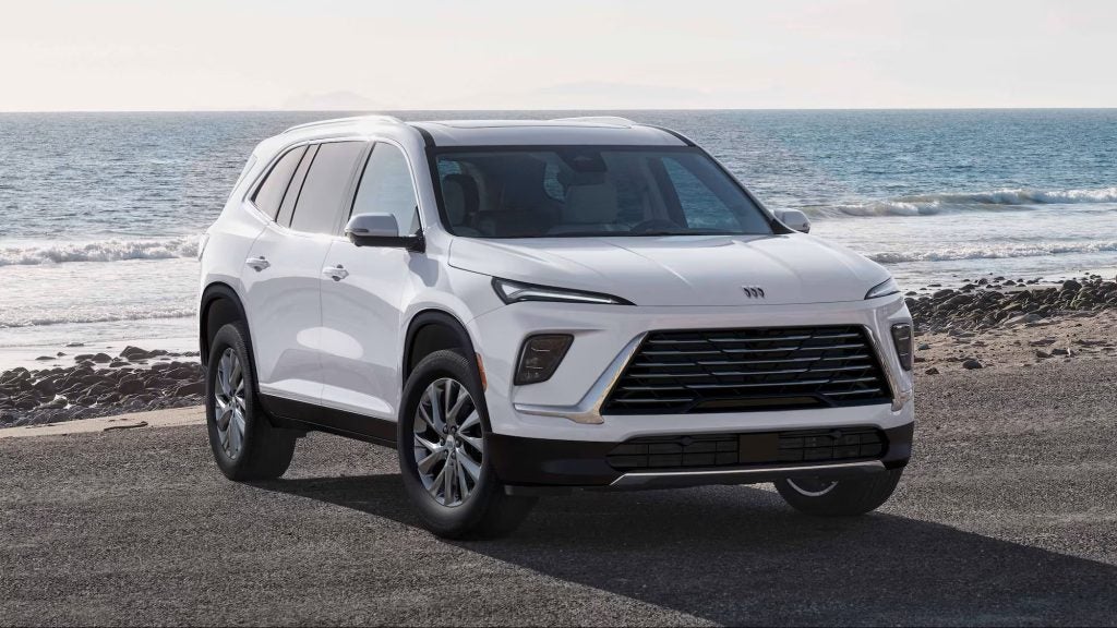 White Buick SUV parked near the ocean shoreline.