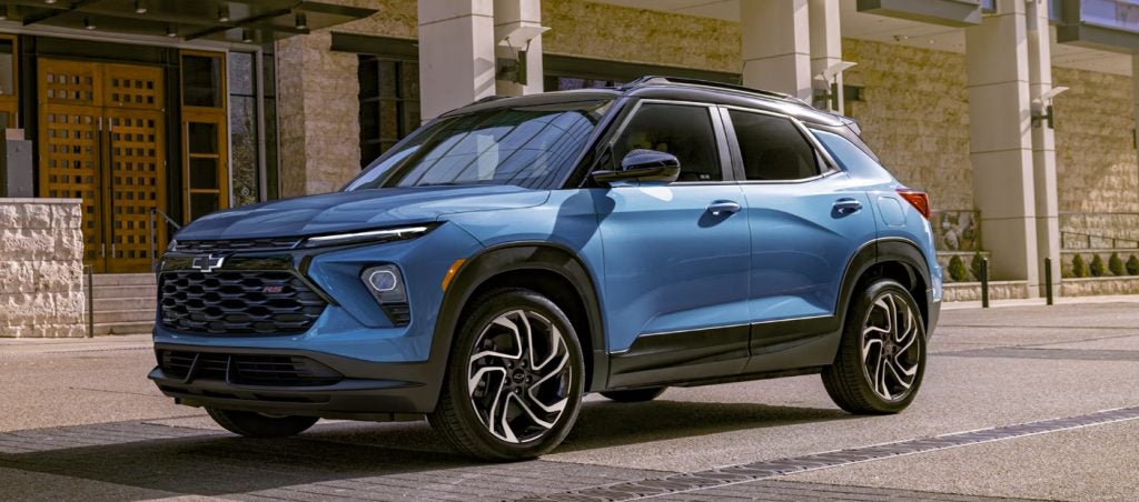 Image of a blue 2025 Chevrolet Trailblazer SUV in front of a stone building