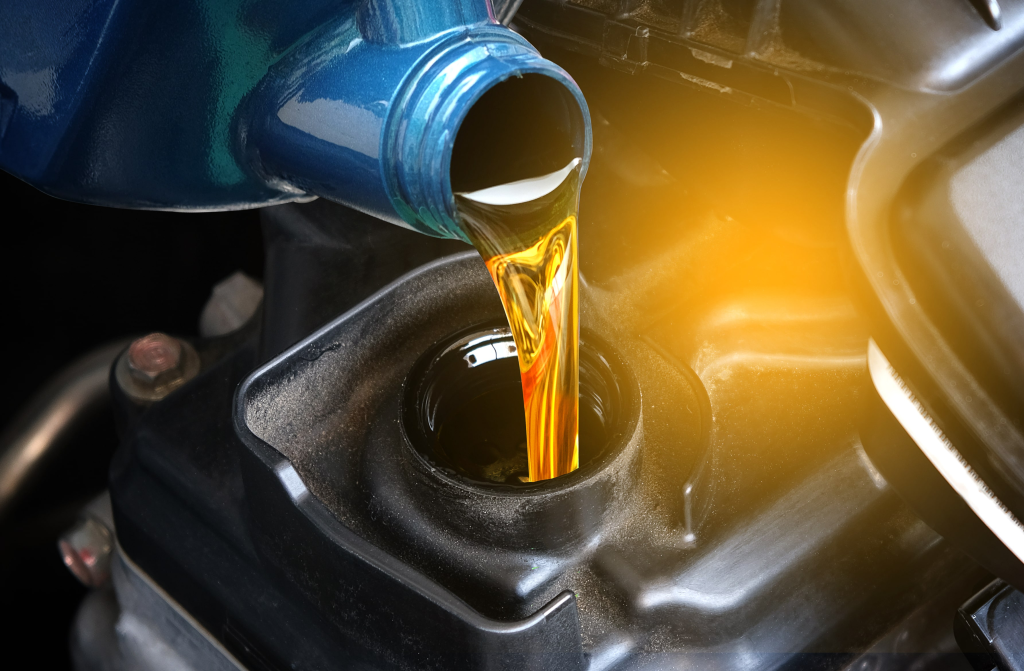 Pouring golden motor oil from a blue container into an engine, with a warm glow illuminating the scene, conveying care and maintenance.
