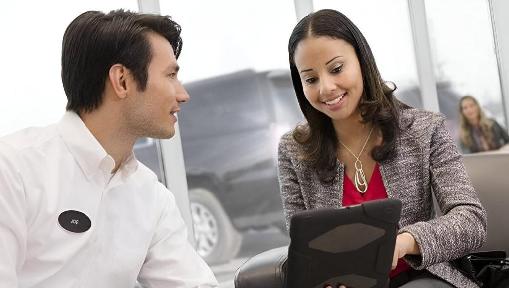Man and Woman at a Dealership looking at a tablet