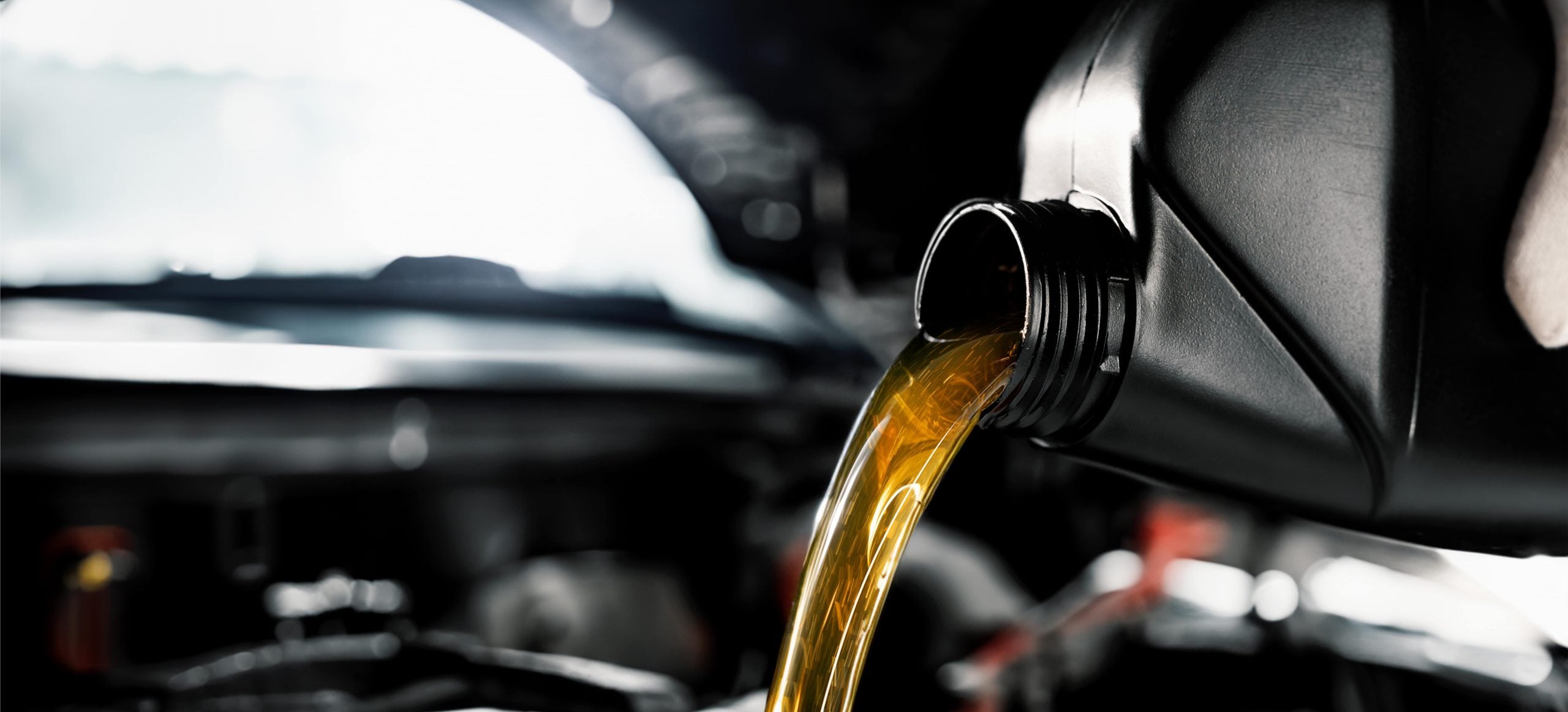 Mechanic adding transmission fluid to an engine