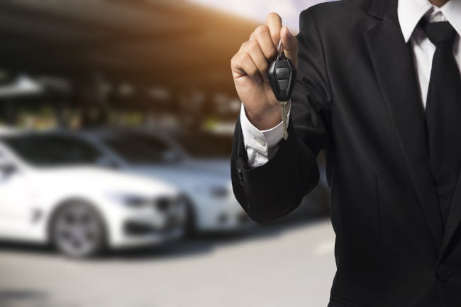 Person holding keys at a dealership