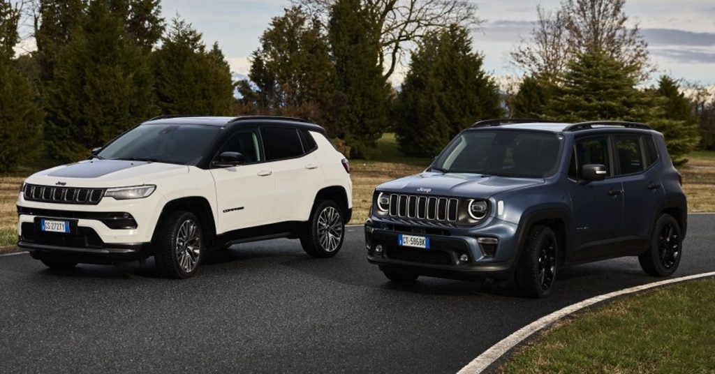 Two Jeep models staged together on a woody road.