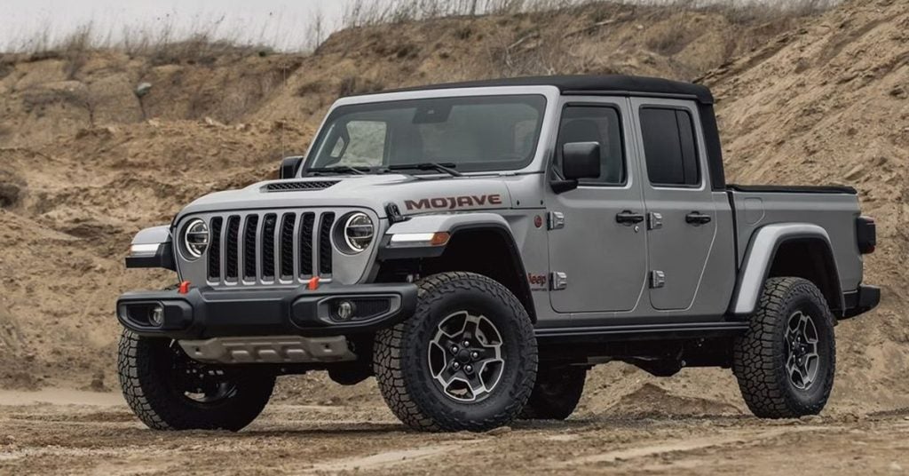 Silver Jeep Mojave in the middle of a canyon.