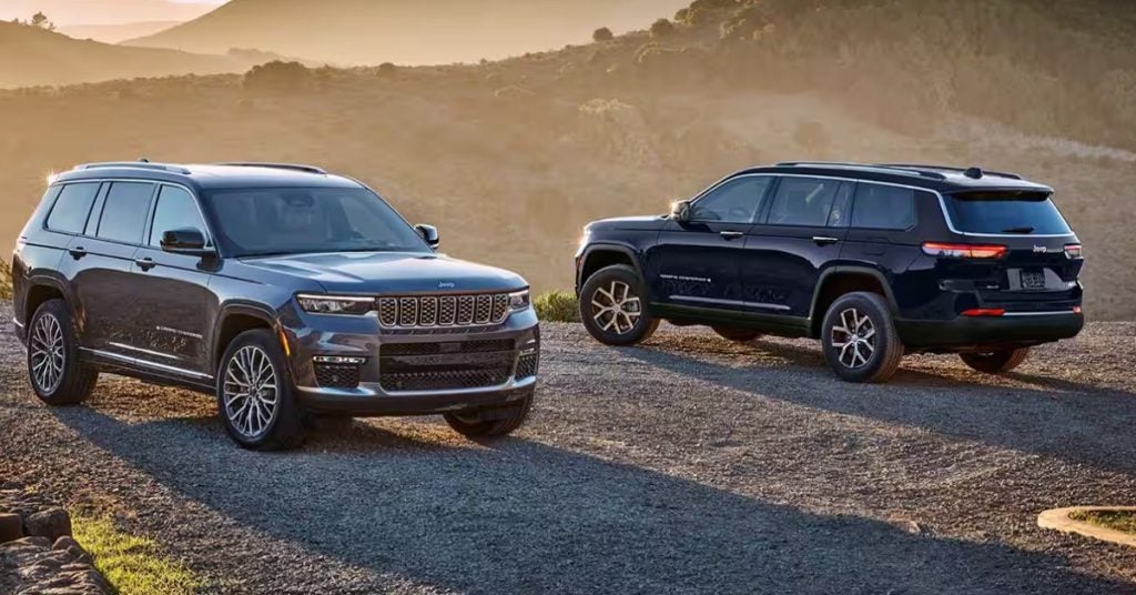 Two Jeep Grand Cherokees in front of a mountain range.