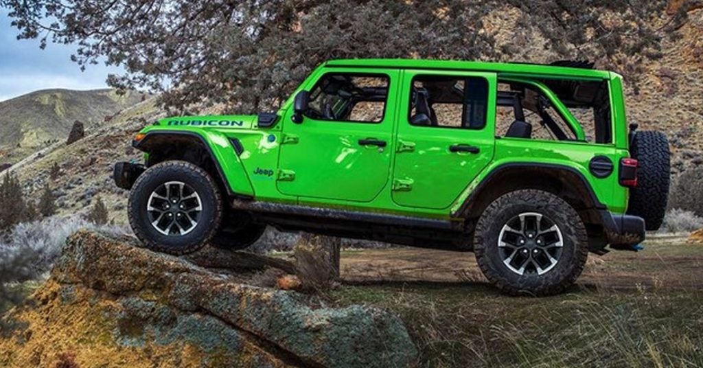 Green Jeep on the edge of a cliff.