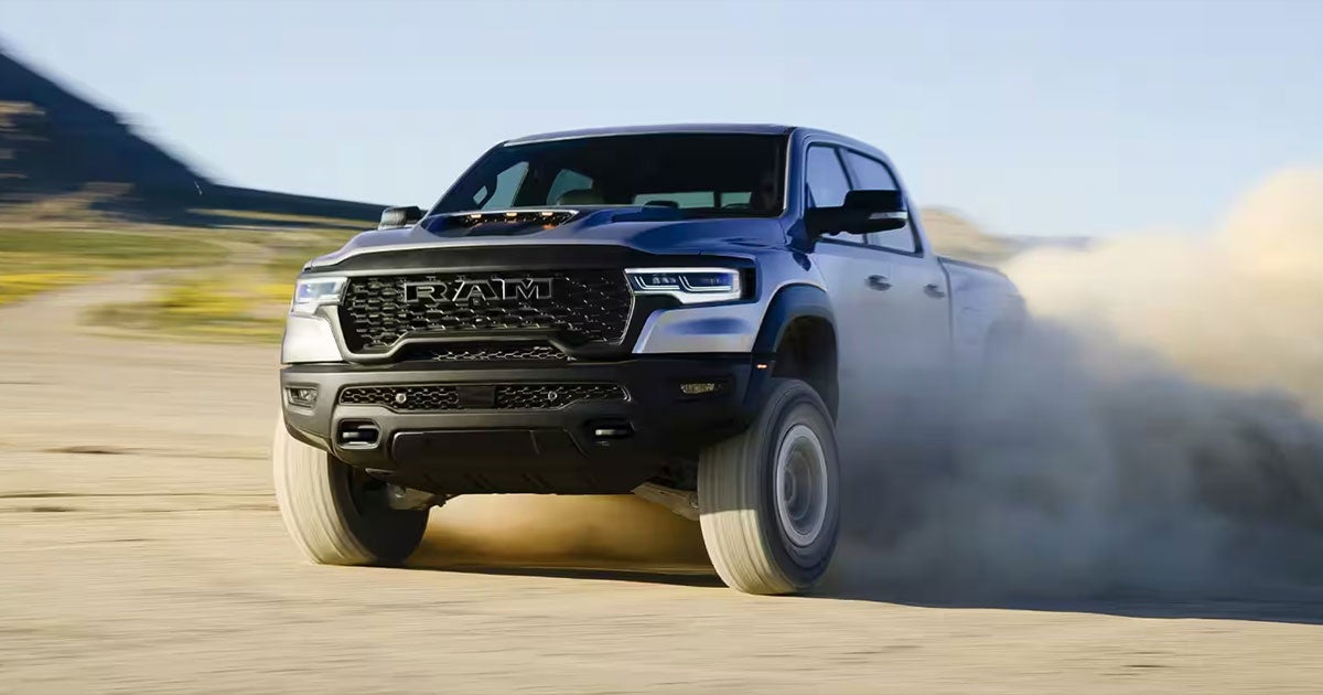 2025 Ram 1500 RHO driving through the sand.