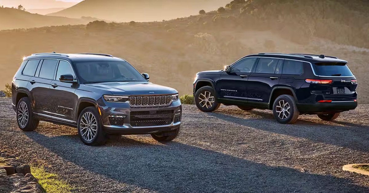 Image of two Jeep Grand Cherokees parked on a mountain road.