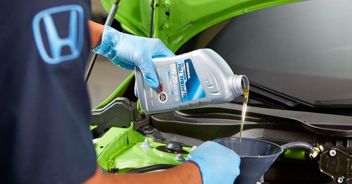 Honda service technician conducting an oil change.