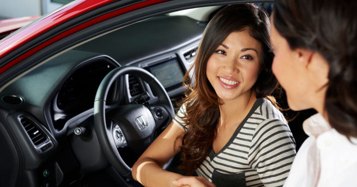 Person in a car speaking with a Honda financing team member