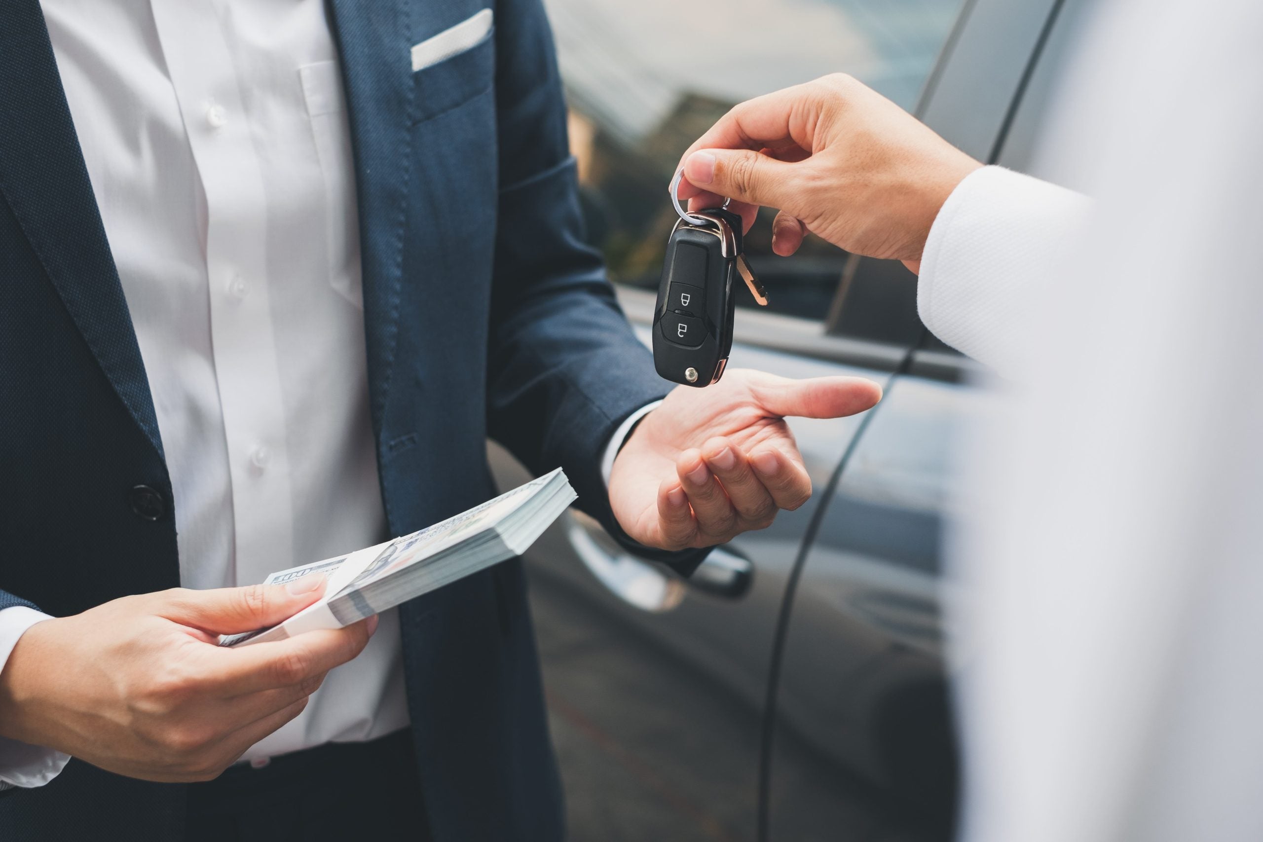 Person exchanging car keys for cash