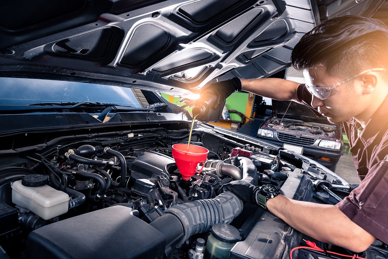 the wide angle image of the technician filling a new lubricant i