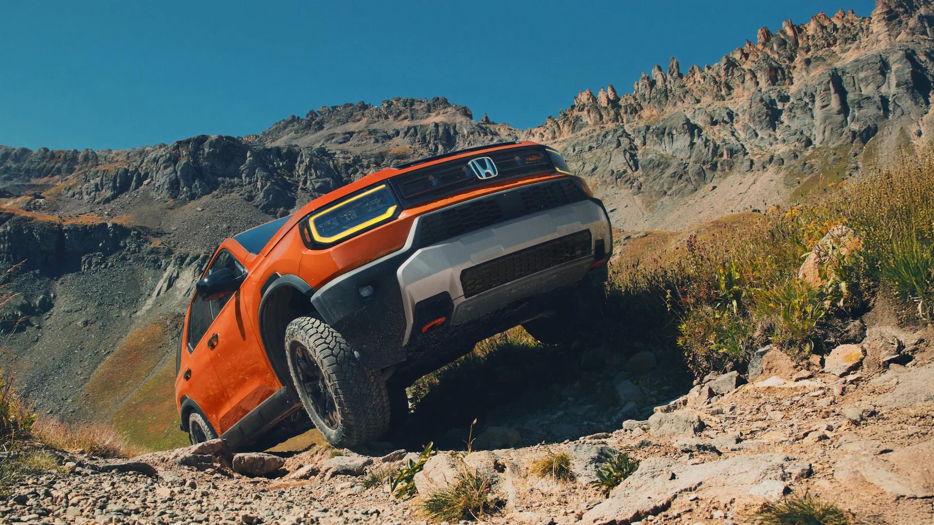 The 2026 Honda Passport, a Honda midsize SUV, driving up a hill