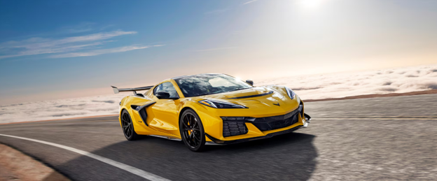 2026 Chevrolet Corvette ZR1 in yellow driving on a scenic mountain road showcasing supercar performance