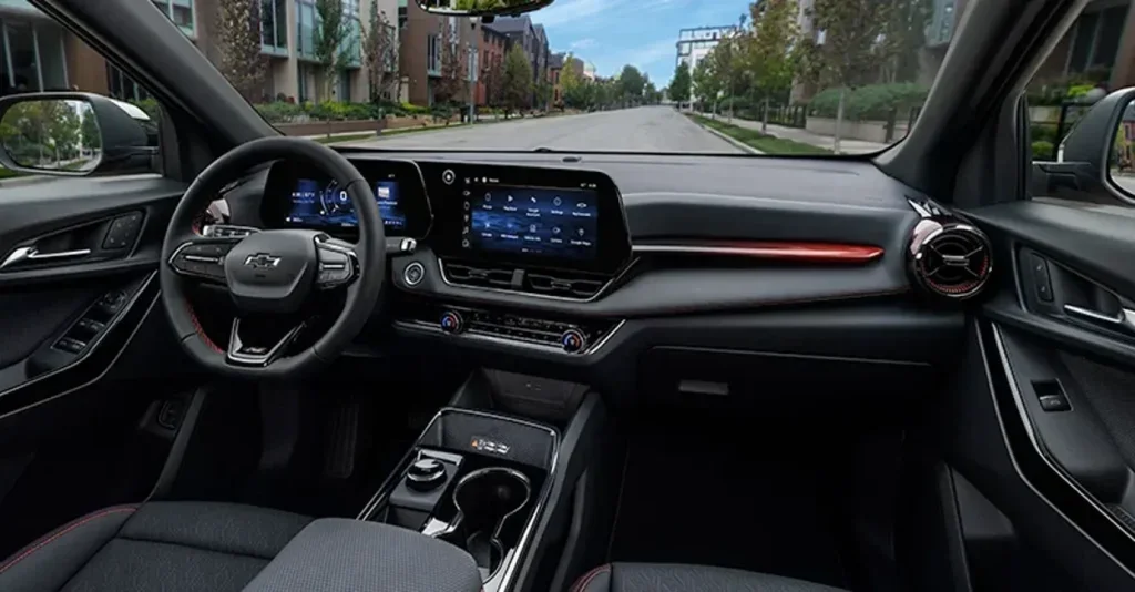 The image shows the interior of a Chevrolet Equinox, with a focus on the modern dashboard featuring dual screens and sleek controls. The cabin is designed with a stylish, minimalist layout, highlighting both comfort and technology.