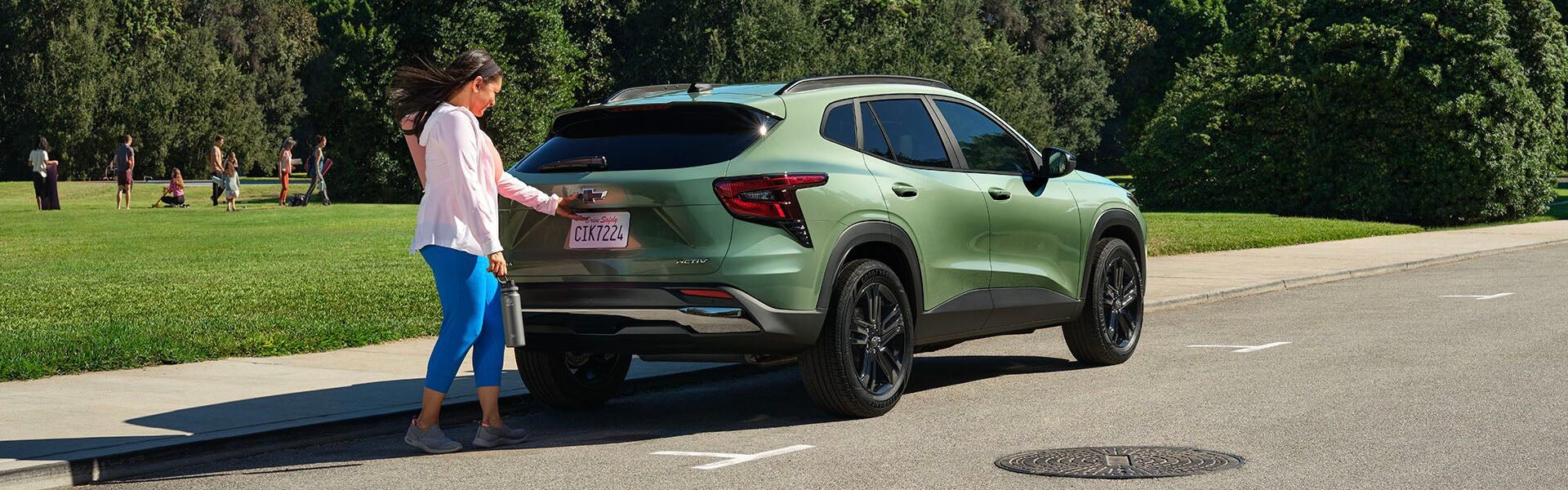 2025 Chevrolet Trax parked on a roadside beside a garden, highlighting its sleek exterior design and rugged compact SUV appeal.