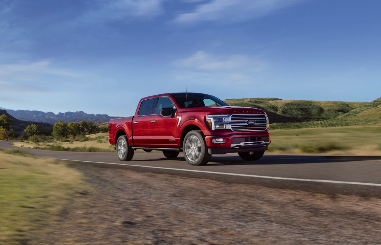 A red Ford F-150 driving on an open road