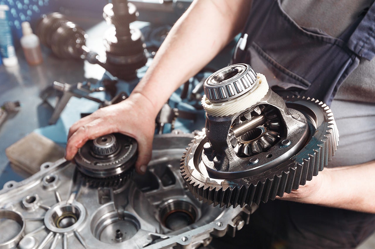 Cross-section of a car gearbox. mechanics work in the garage. hand mechanic in working clothes