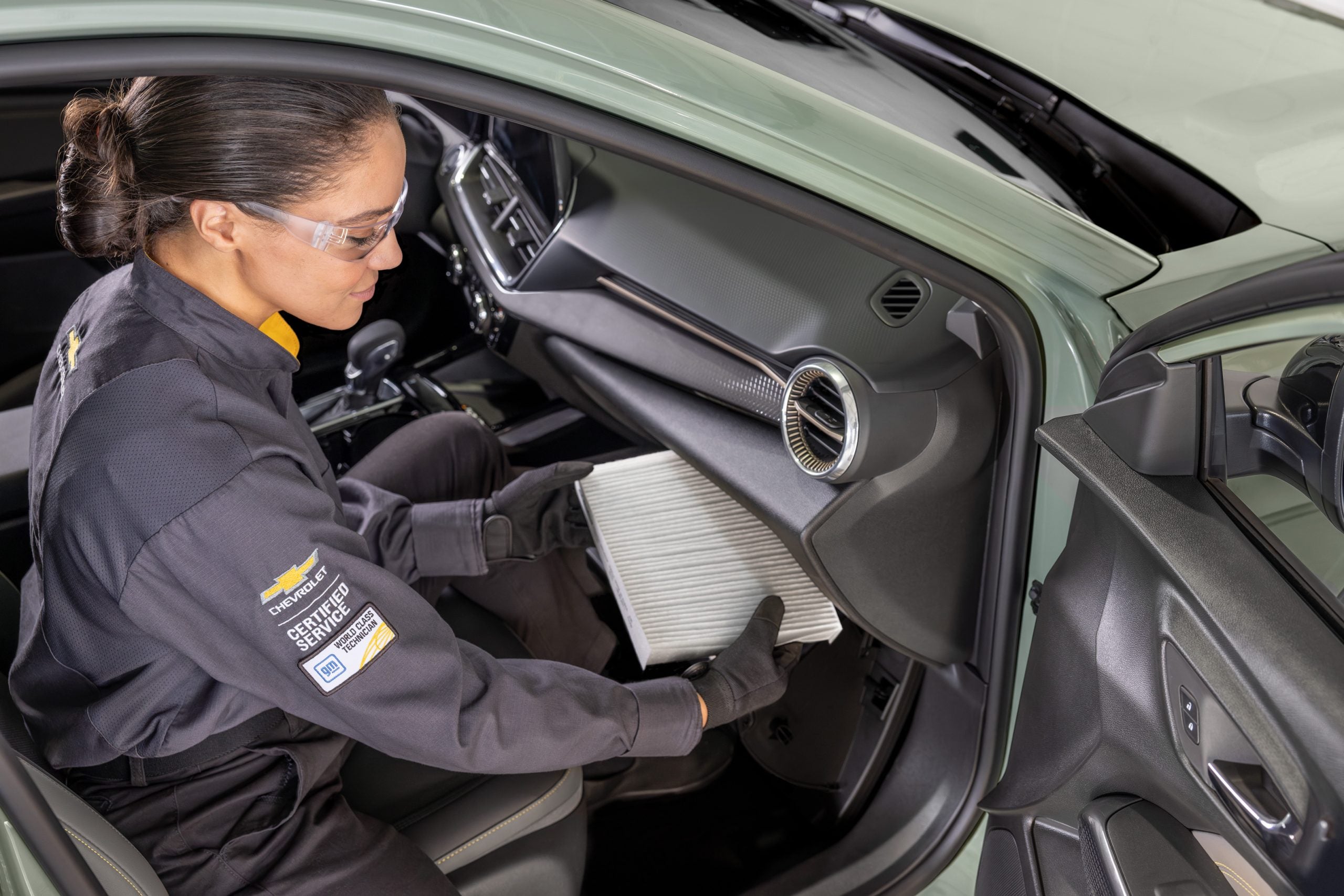 Chevy service tech installing a cabin air filter.