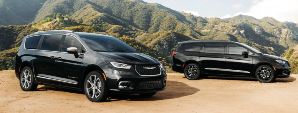 two Chrysler Pacificas parked in front of mountains