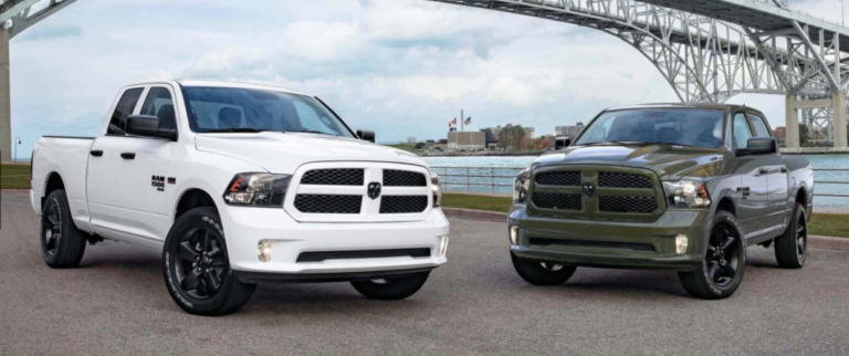 two Dodge Ram 1500 classics parked in front of a bridge
