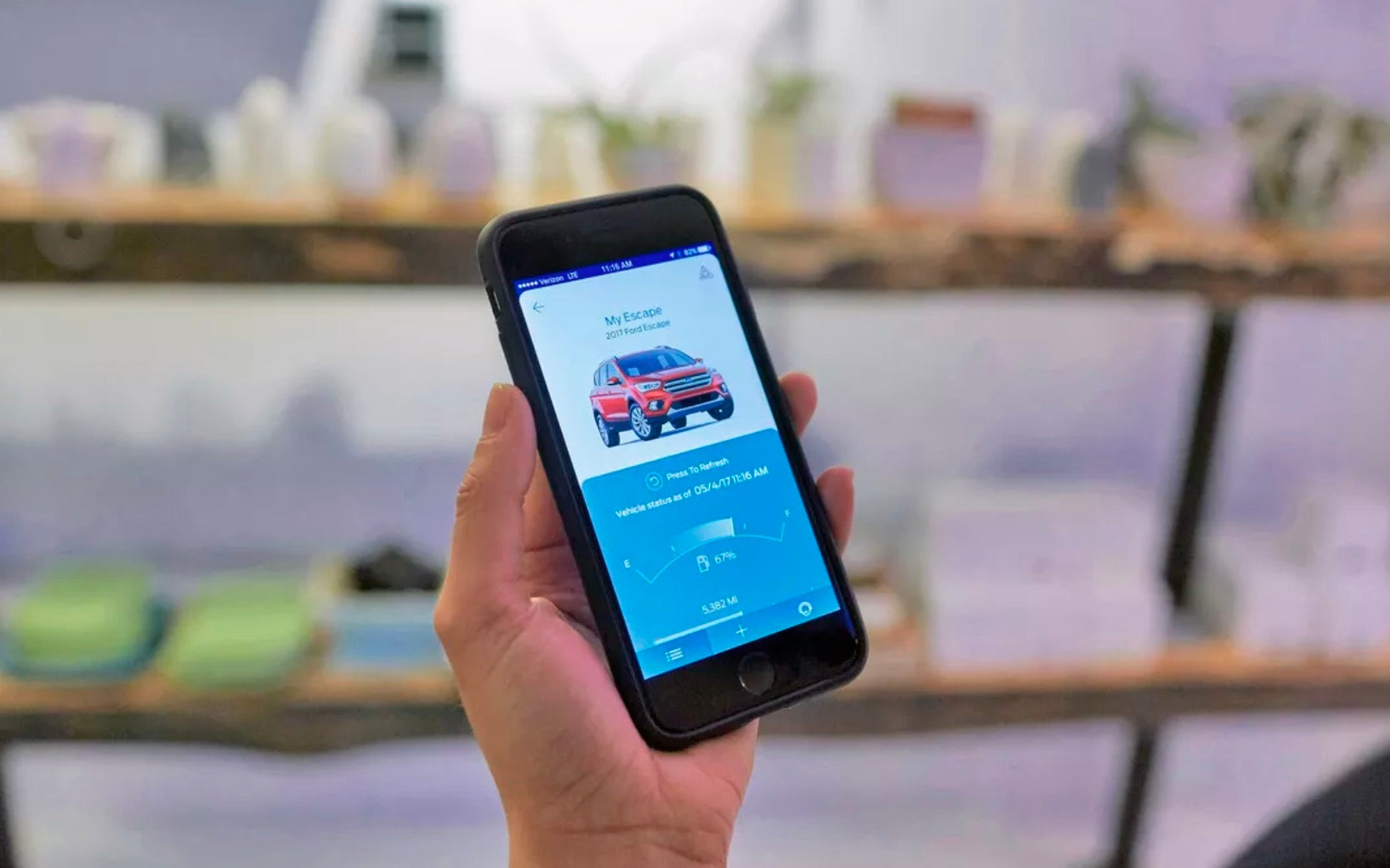 customer holding a phone displaying the FordPass mobile app