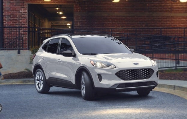 Ford Escape in white parked in front of a brick building
