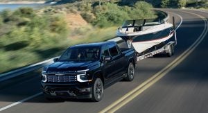 2027-chevrolet-silverado-1500-black-towing-boat-trailer-highway