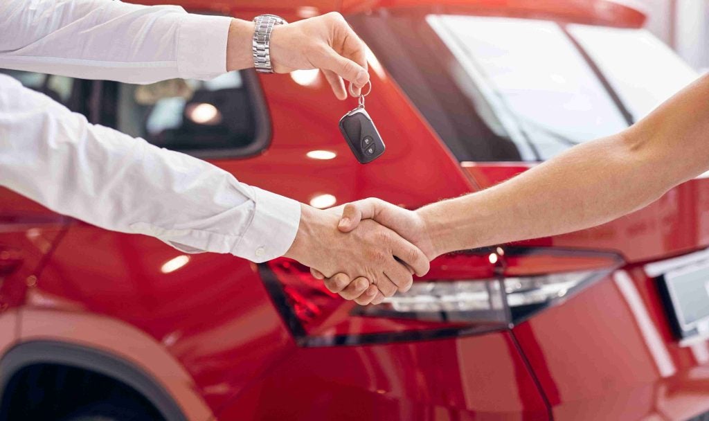 People shaking hands and exchanging keys