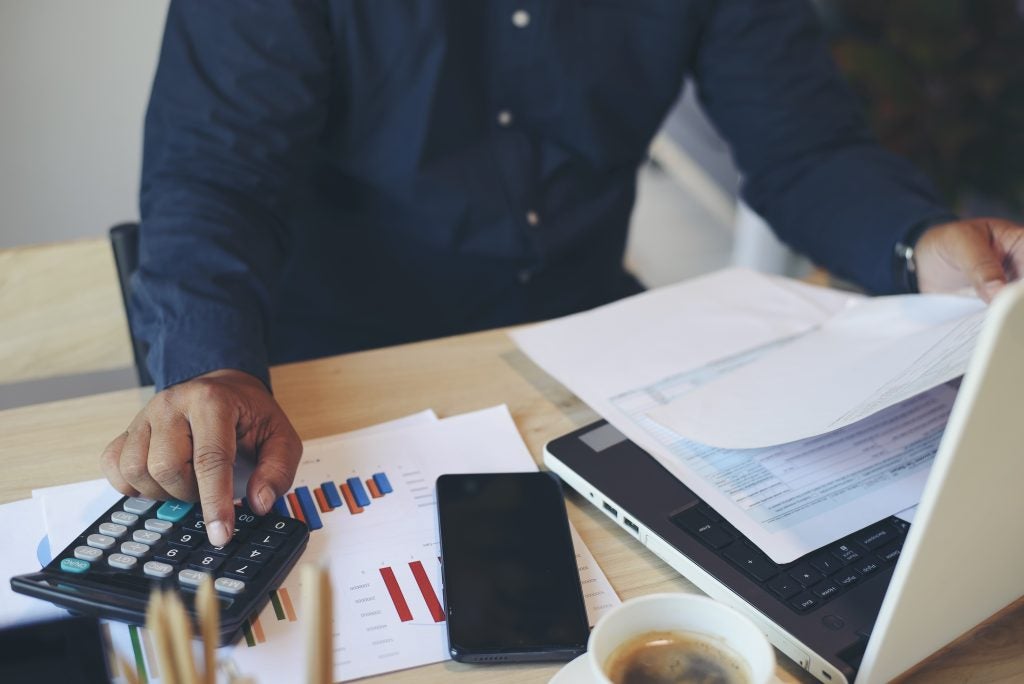 Budget and Tax planning concept, Accountant Hand is calculating company annual tax and using calculator. Personal income tax form for who have income under US law, season to pay tax.
