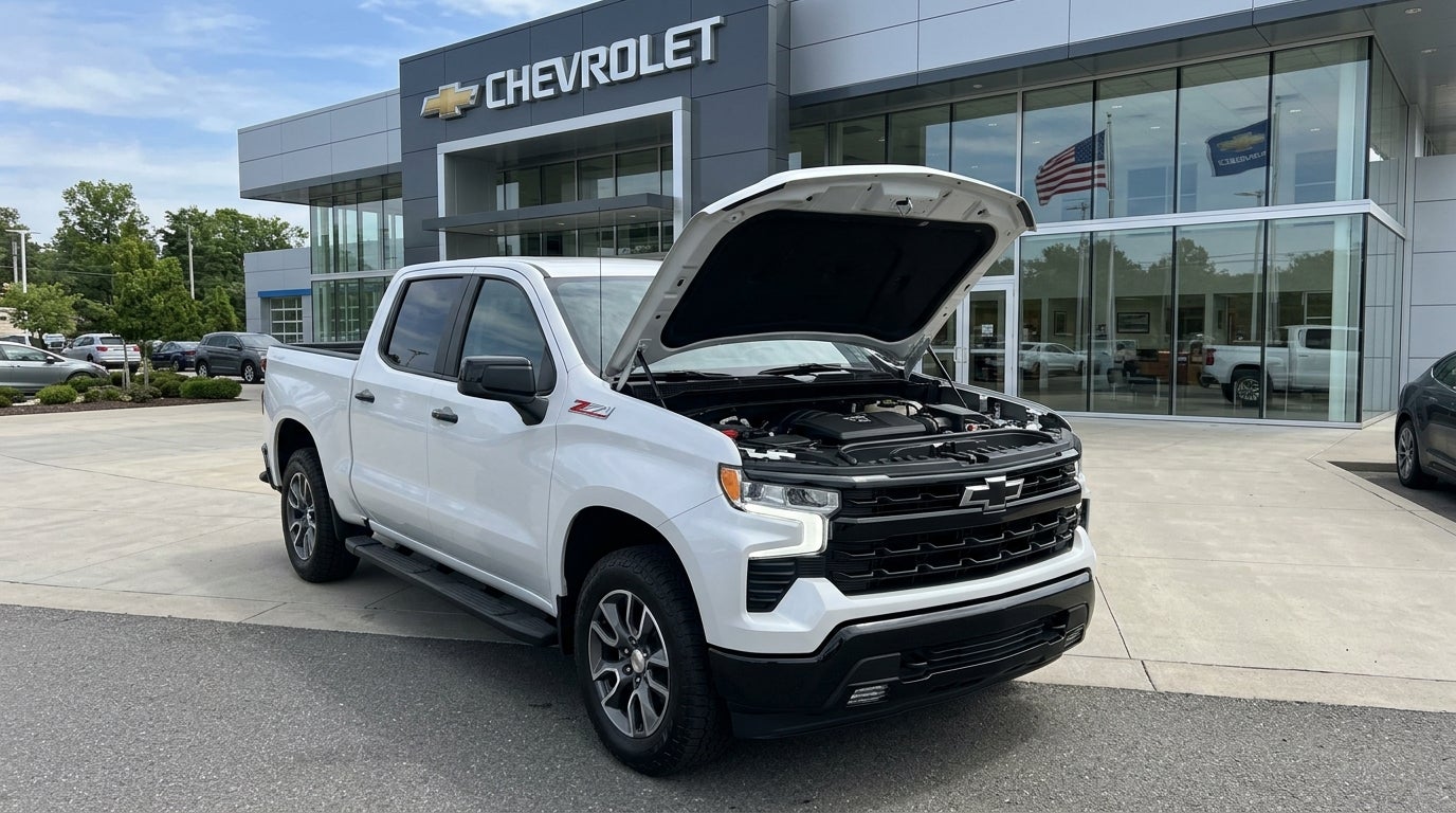White Chevrolet Silverado truck with its hood open parked in front of a Chevrolet dealership. (Representative image for illustration purposes only. Actual vehicle may vary based on trim and configuration.)