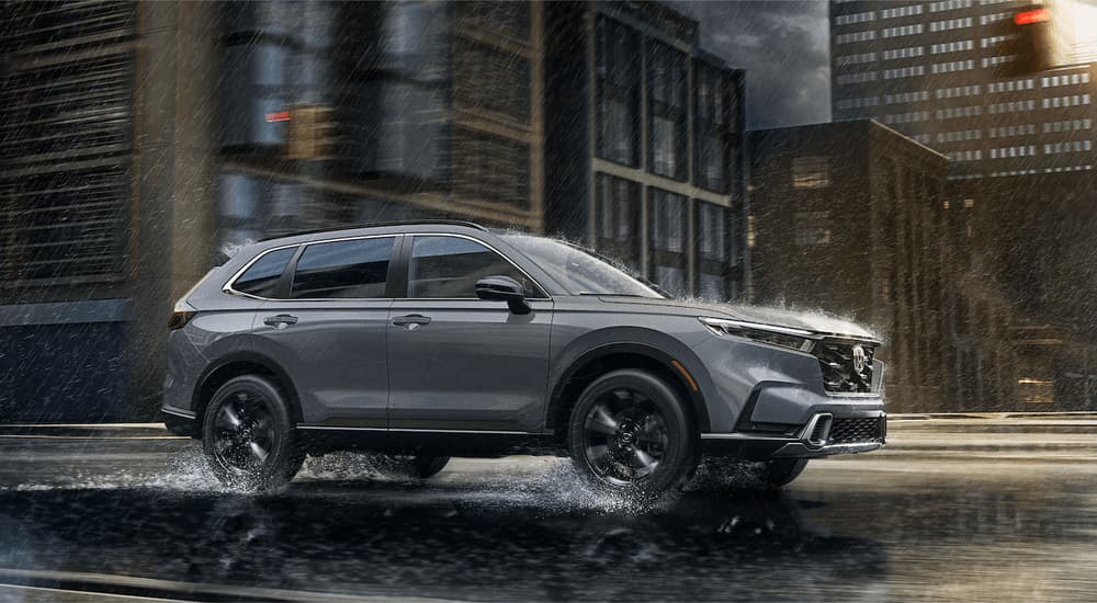 Grey 2023 Honda CR-V driving on a rainy day.