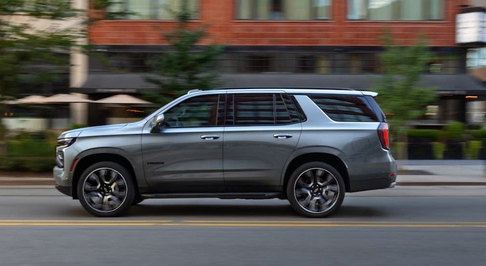 A silver 2026 Chevy Tahoe driving in a city.
