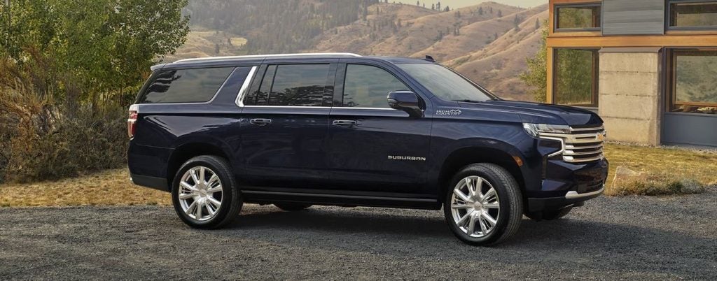 Side view of a parked, blue 2024 Chevy Suburban.