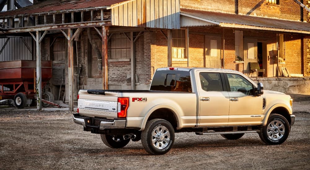 Silver 2012 Ford F-350 parked outside of a brick barn.