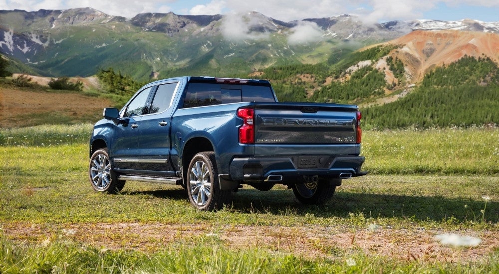 A blue 2025 Chevy Silverado 1500 High Country on a field.